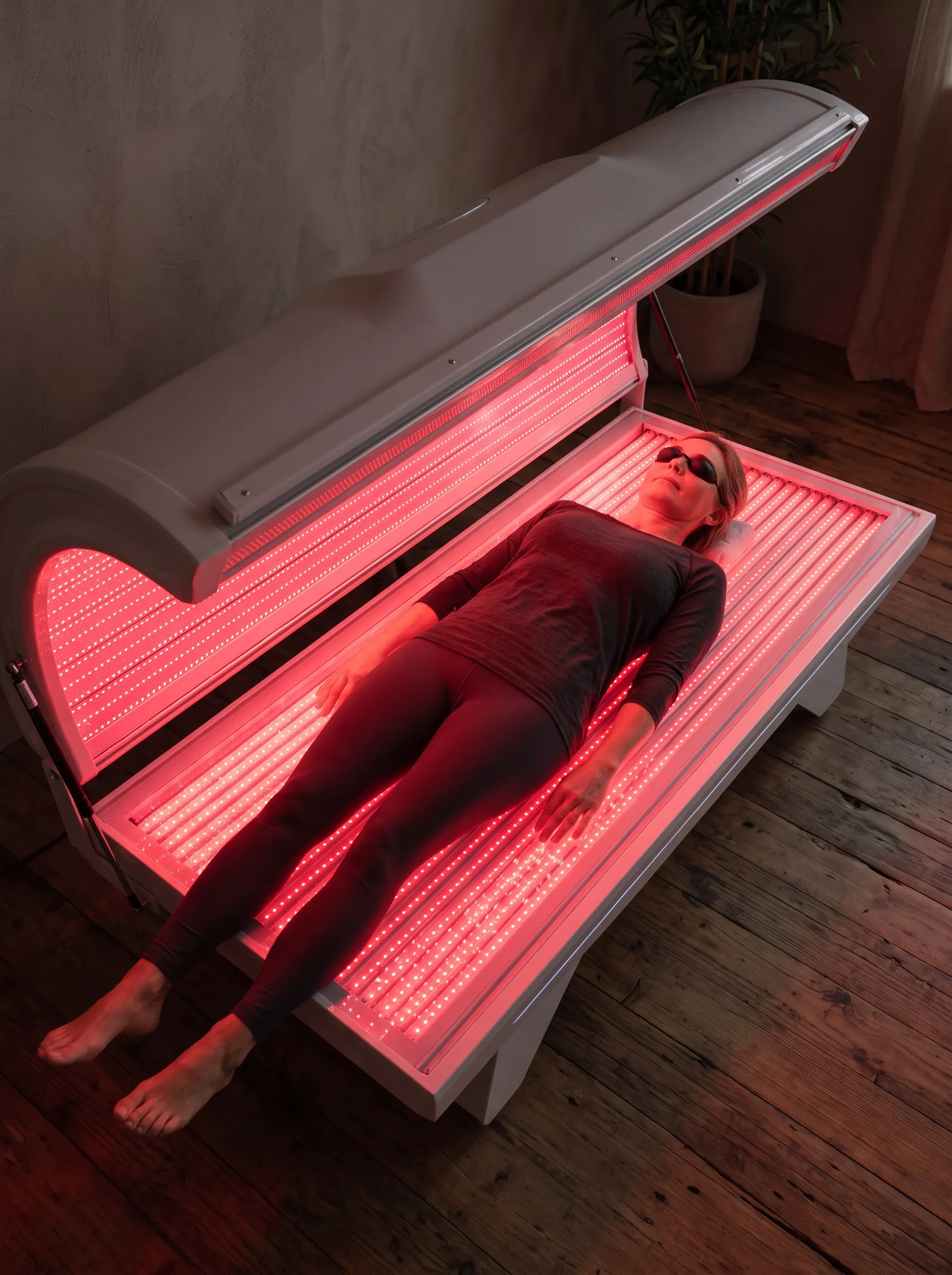 A woman lying inside the bed, panels lit above and below her.
