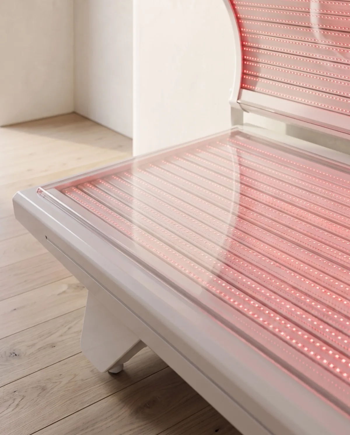 Raking light across the acrylic lying surface, the emitter grid visible beneath it.