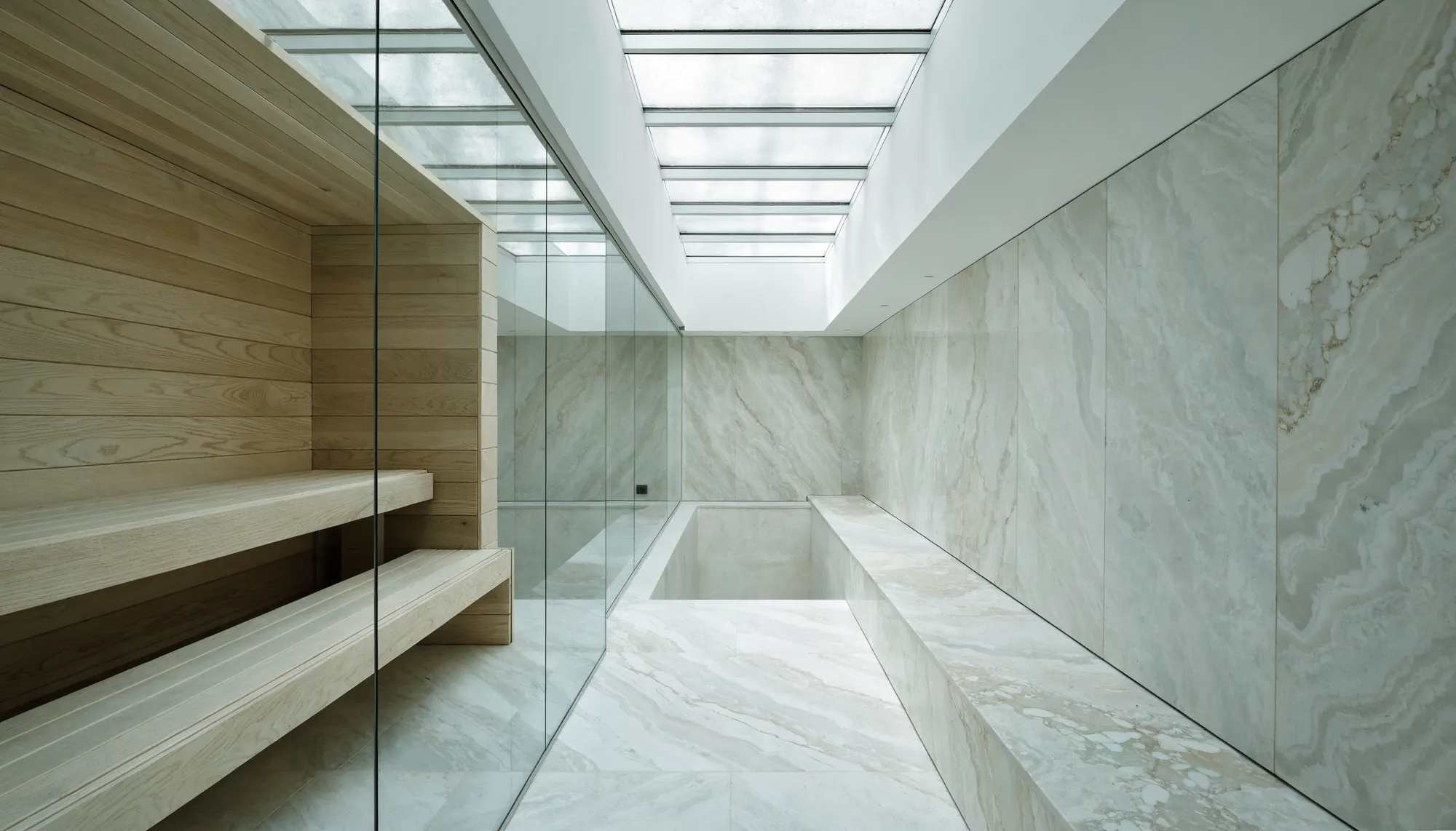 A marble and oak wellness suite with sauna and plunge