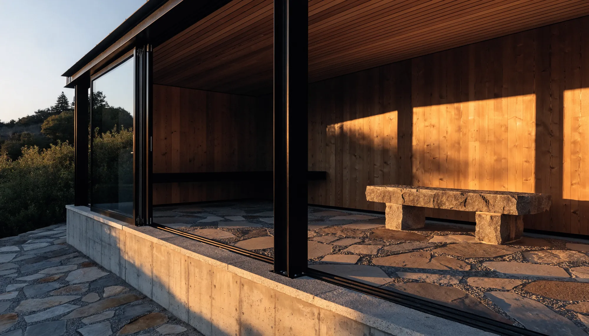A blackened steel pavilion opening to a terrace