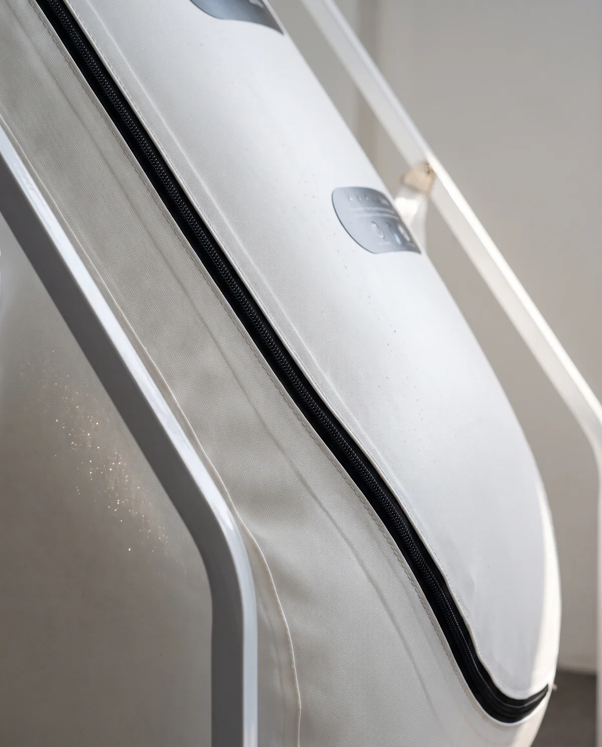 Close detail of the frame junction and the curved zip on the white TPU cabin.